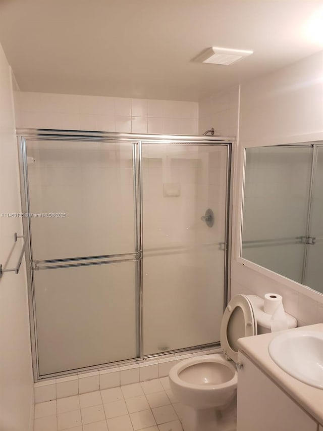 bathroom with vanity, toilet, an enclosed shower, and tile patterned flooring