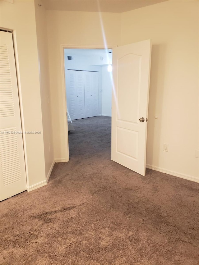 hall with dark colored carpet