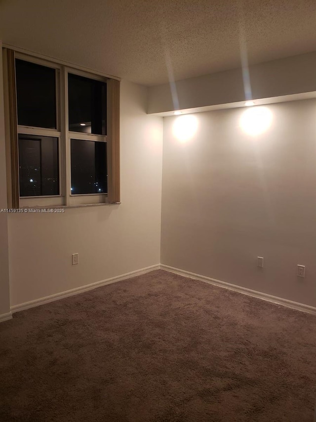 carpeted spare room featuring a textured ceiling