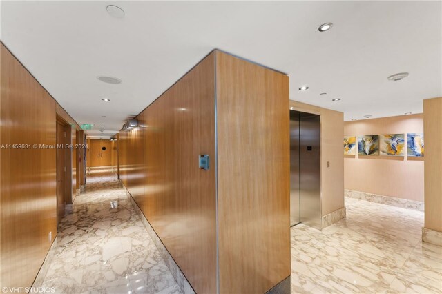 corridor with wood walls and elevator