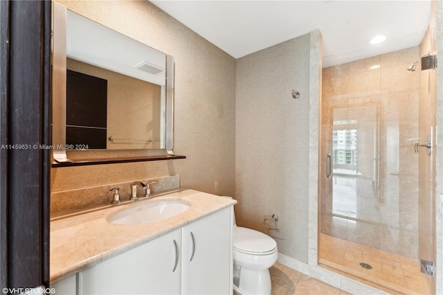 bathroom with tile patterned flooring, a shower with shower door, vanity, and toilet