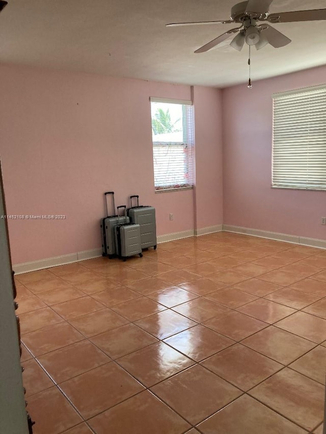 tiled spare room featuring ceiling fan