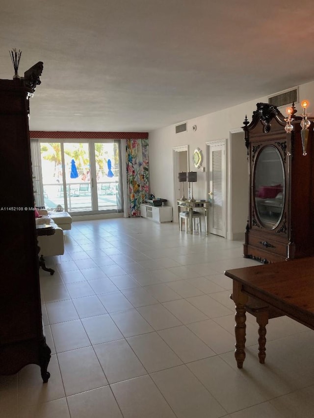 tiled living room with a notable chandelier