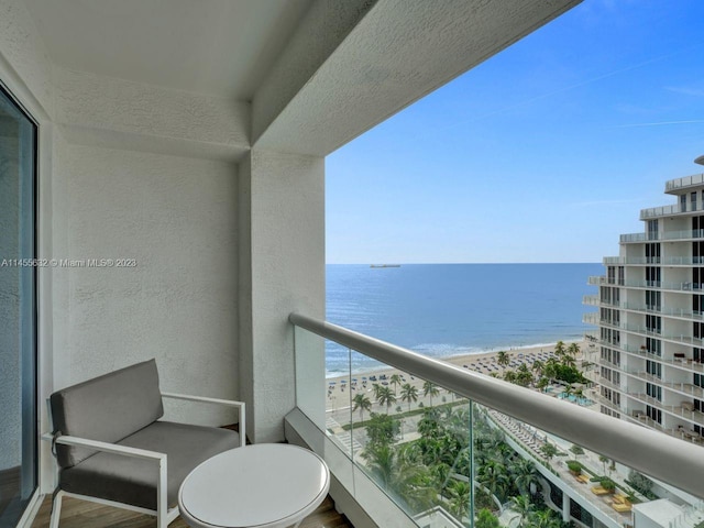 balcony featuring a water view and a beach view