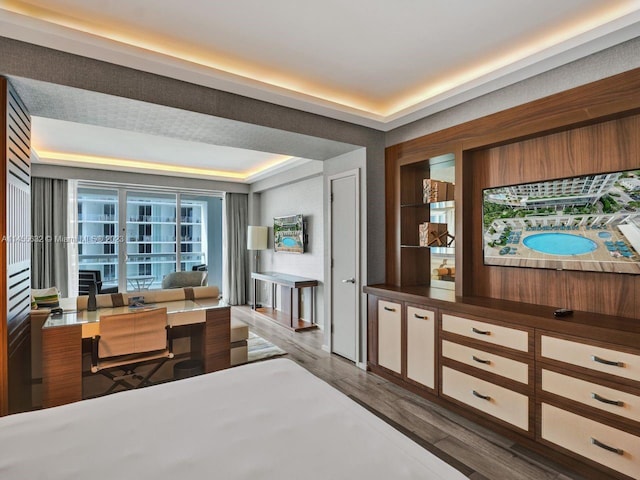 bedroom with a tray ceiling and dark hardwood / wood-style flooring