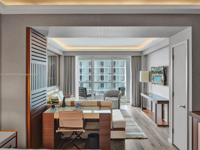 office area featuring a raised ceiling and light wood-type flooring