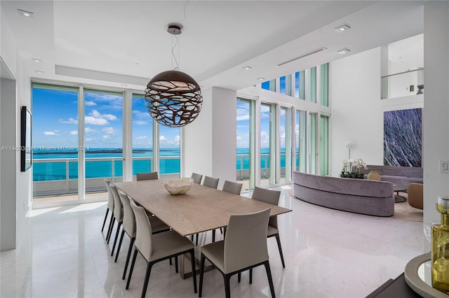 dining area featuring a water view and a wall of windows