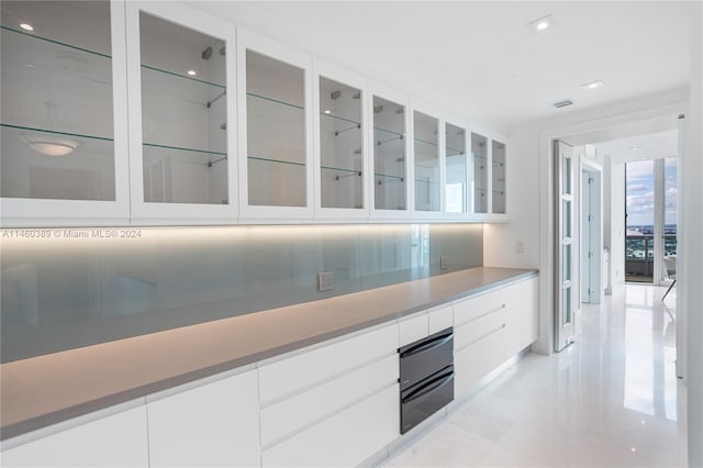 interior space with decorative backsplash and white cabinetry