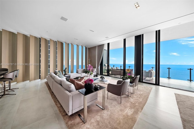 tiled living room featuring a water view and a wall of windows