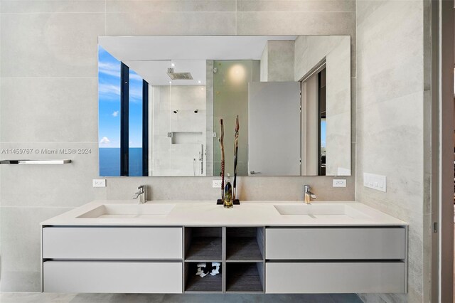 bathroom with double sink vanity and tile walls