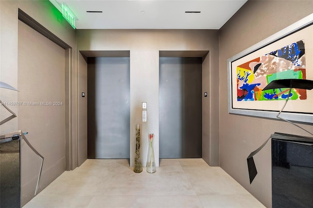 hallway with light tile floors and elevator