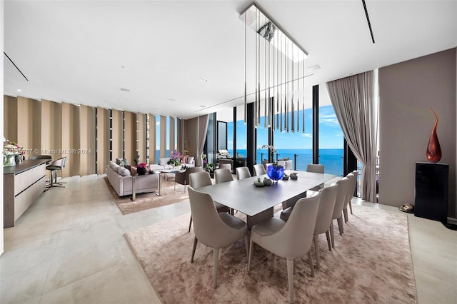 tiled dining room featuring floor to ceiling windows and a water view