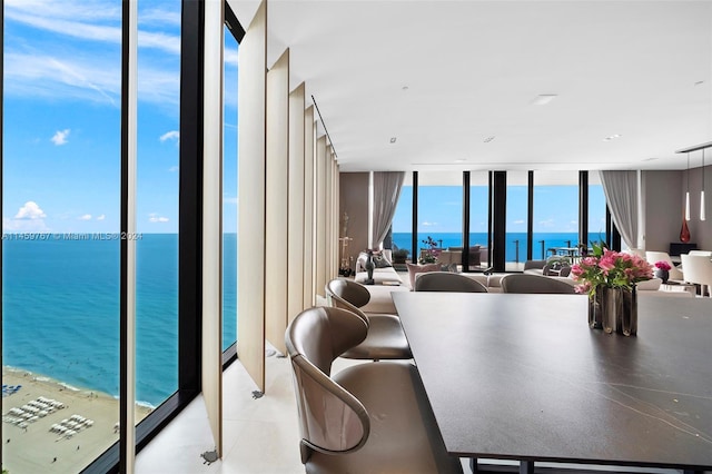 dining space featuring floor to ceiling windows and a water view