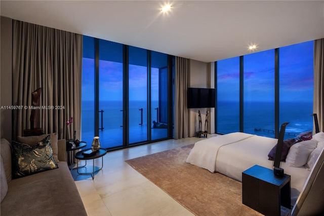 tiled bedroom featuring floor to ceiling windows and a water view