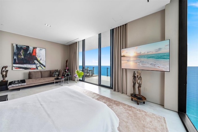 bedroom featuring expansive windows, access to outside, and a water view