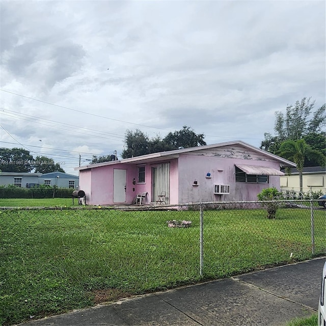 manufactured / mobile home featuring a front yard, fence, and stucco siding