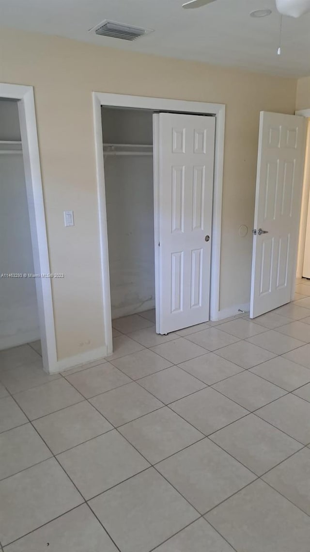 unfurnished bedroom featuring a closet, ceiling fan, and light tile floors