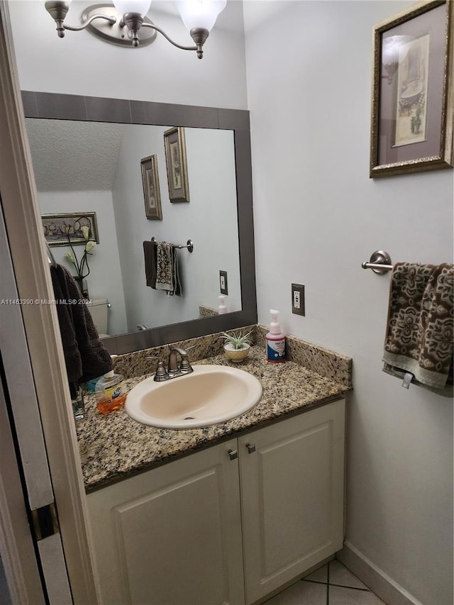 bathroom with vanity, tile patterned flooring, and toilet