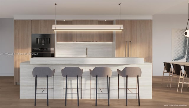 kitchen featuring a breakfast bar area, pendant lighting, and light wood-type flooring