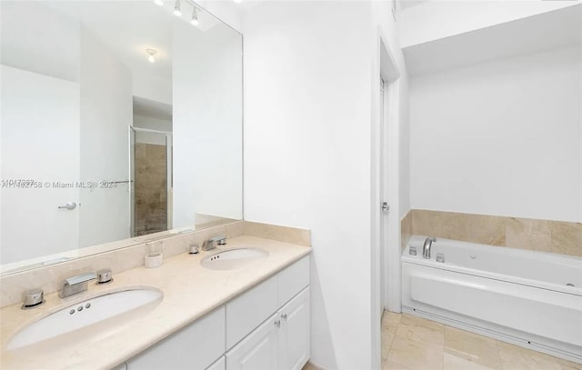 bathroom with tile floors, large vanity, dual sinks, and a bathing tub