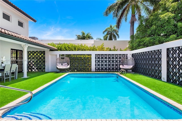 view of swimming pool with a lawn