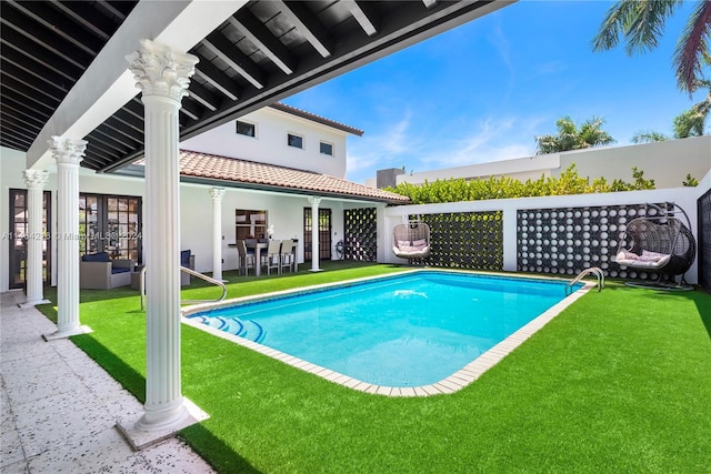 view of swimming pool with a patio and a lawn