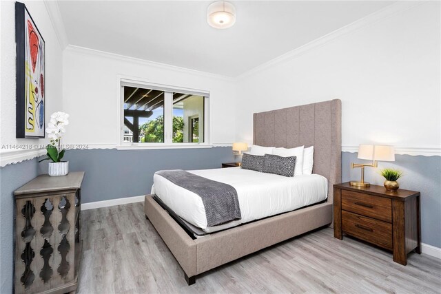 bedroom featuring light hardwood / wood-style floors and crown molding