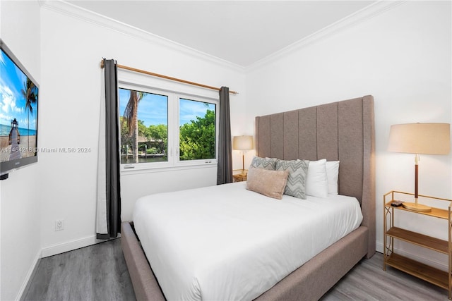 bedroom featuring ornamental molding and wood-type flooring