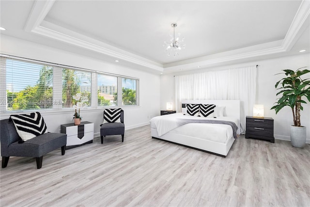 bedroom featuring light hardwood / wood-style floors, a raised ceiling, crown molding, and a chandelier