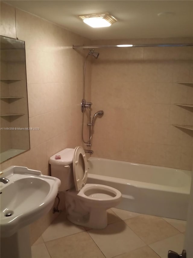 bathroom with tile walls, tiled shower / bath combo, tile patterned floors, and toilet