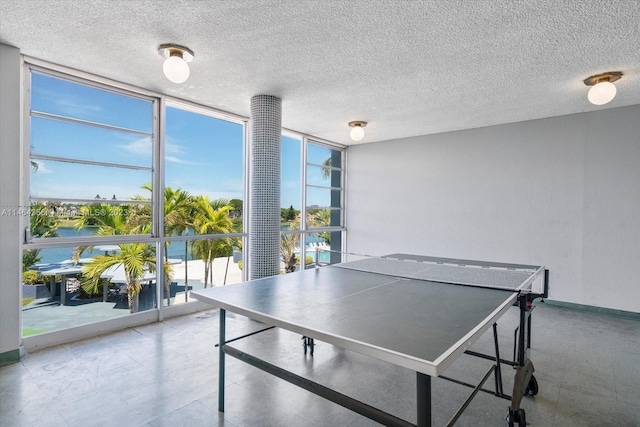 rec room featuring tile patterned flooring, a wall of windows, and a textured ceiling