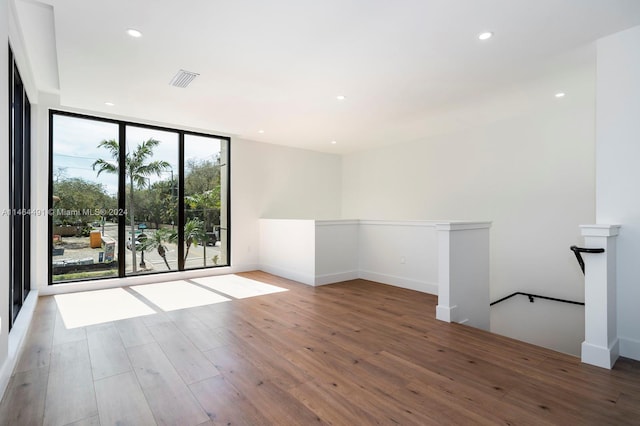 empty room featuring dark hardwood / wood-style floors and expansive windows