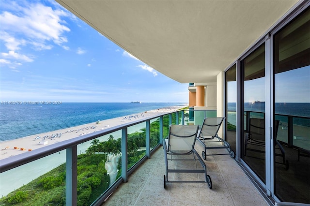 balcony featuring a water view and a beach view