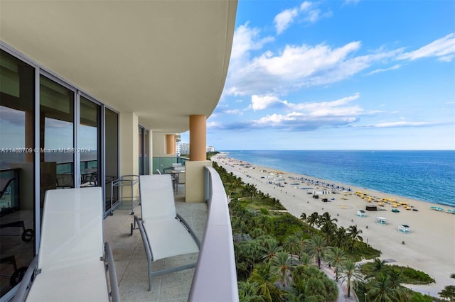 balcony featuring a water view and a beach view