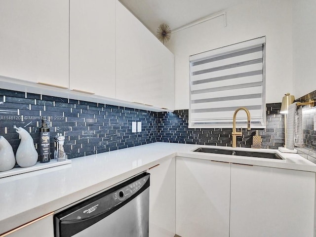 kitchen with white cabinets, backsplash, stainless steel dishwasher, and sink