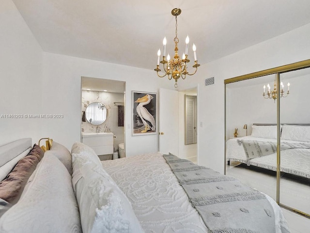 bedroom with a closet, a notable chandelier, and ensuite bath