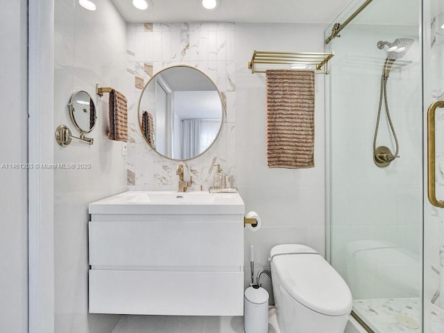 bathroom with tile walls, toilet, vanity, and tiled shower