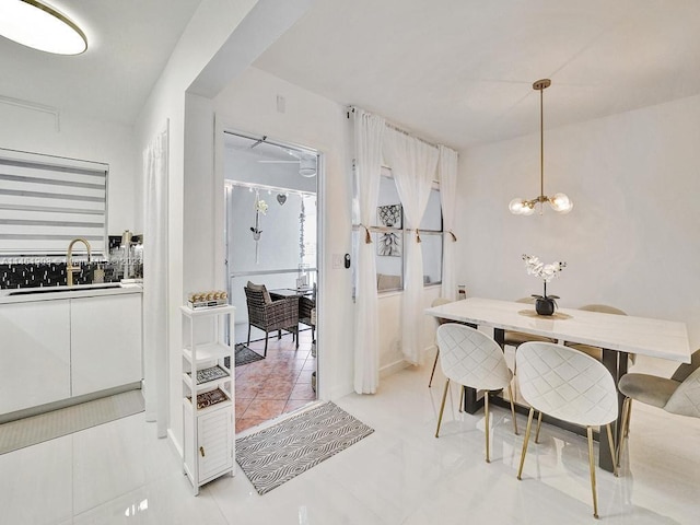 dining room featuring a notable chandelier, light tile floors, and sink