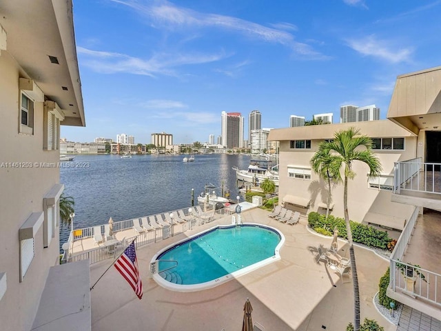 view of swimming pool with a water view and a patio area