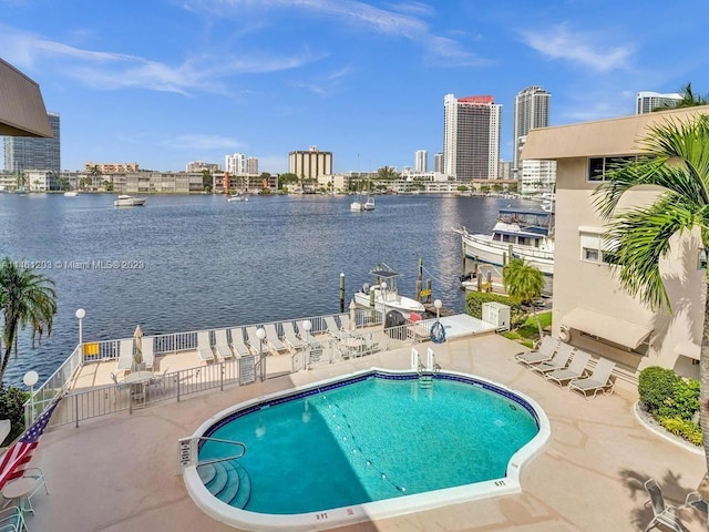 view of pool with a patio area and a water view