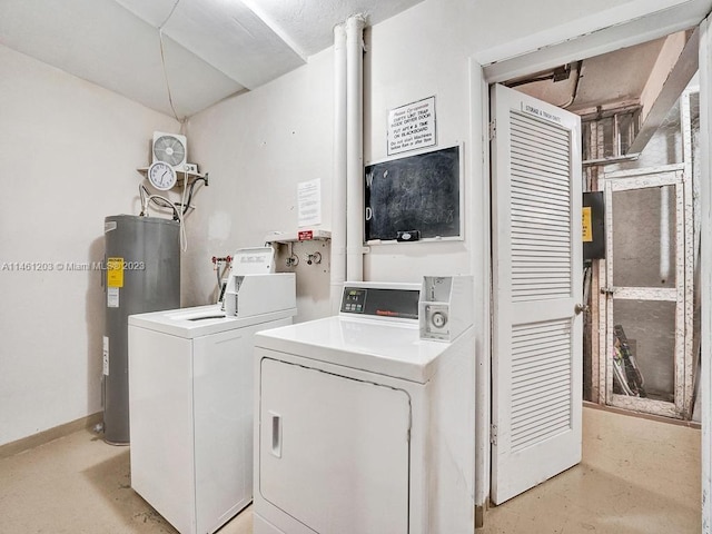 clothes washing area featuring electric water heater and washing machine and clothes dryer