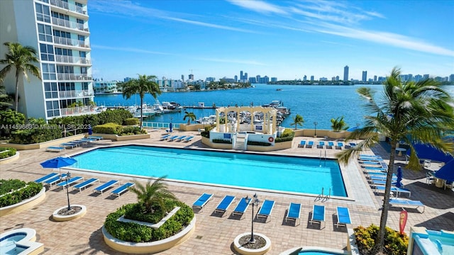 view of swimming pool featuring a water view and a patio