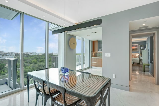 dining room with a wall of windows and light tile floors