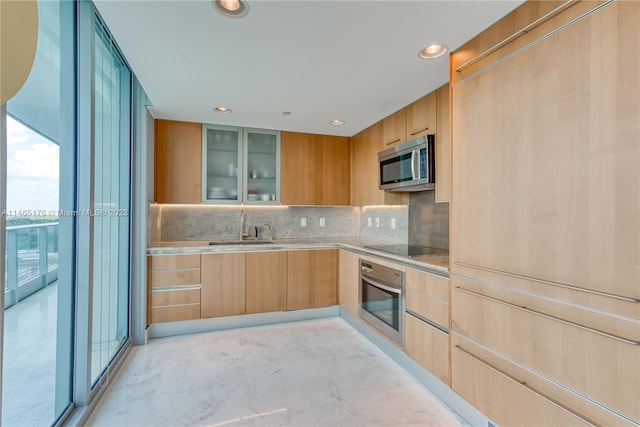 kitchen featuring backsplash, light brown cabinets, stainless steel appliances, and sink