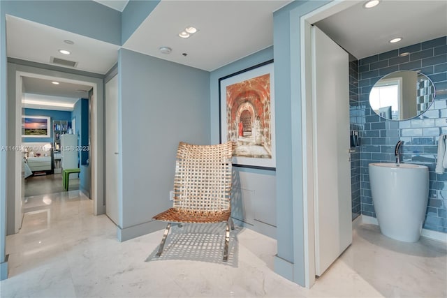 hall featuring tile walls and light tile floors