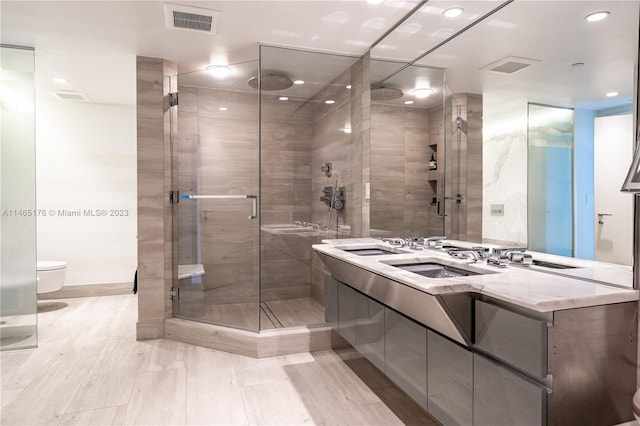 bathroom with vanity, a shower with shower door, and toilet