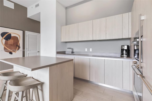 kitchen with a kitchen island, a breakfast bar area, sink, and black electric stovetop