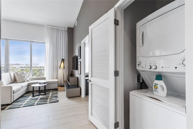 washroom featuring light hardwood / wood-style floors and stacked washing maching and dryer