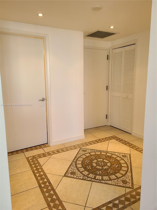 hall featuring light tile flooring