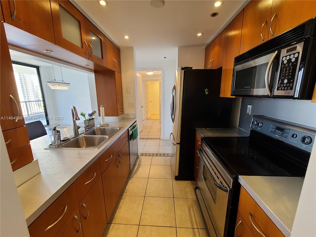 kitchen featuring hanging light fixtures, stainless steel appliances, sink, and light tile floors